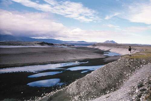 FIGURE 11 Catastrophic flood erosion, Iceland. In 1996 a volcanic eruption beneath the Vatnajökull ice cap triggered a jökulhlaup (glacier outburst flood) having roughly quadruple the flow of the Mississippi River. The flood tore down two small rivers draining the ice cap’s outwash plain (Skeiðarársandur), denuding the landscape by nearly 25 m in some areas (shown here) and depositing up to 12 m of gravel in others, Iceland’s circum-Island highway crossing the plain was destroyed (Smith Citation2020). [Well-being] (Author photo, 1997).