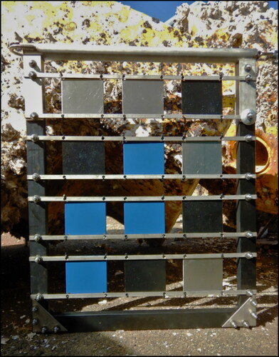 Figure 2. BioFREE biofouling monitoring and testing frame: coating and material testing systems have been designed, manufactured and deployed following extensive consultation with MRE operational staff and developers, hydrodynamicists, and statisticians. In this image, the frame has been rotated 90°, showing the hoist at the top. Note: heavily fouled mooring structures in background.