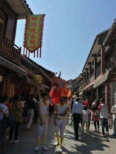 Figure 7. Cultural performance at the cross streets of Qingyan. The streets are packed with tourists