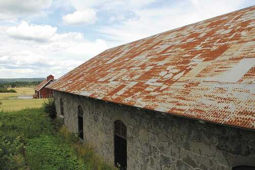 Figure 10. An example of our threatened ferrous heritage — corrugated steel sheet roofing of listed barns at the Björneberg Manor in Sweden. The corrosion products would need to be removed and the surface cleaned prior to painting, as for all anticorrosive treatments. Photo by author.
