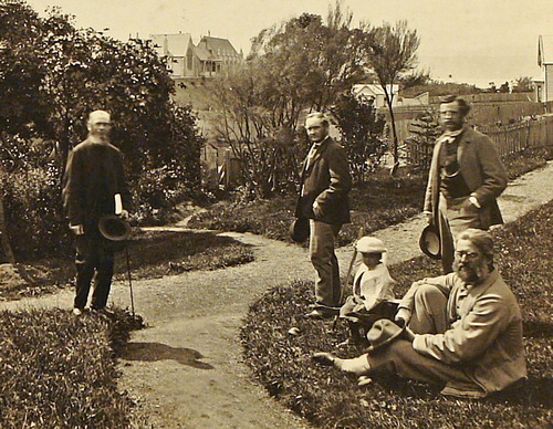 Figure 2. Group photographed in the garden of Walter Mantell (near the present Parliament Buildings, Wellington) in 1865 or 1866. From left: Charles Knight (auditor-general and amateur botanist), John Buchanan, infant Wally Mantell, James Hector, and Walter Mantell (seated on grass). Although Buchanan had working class origins, the photograph illustrates that he mixed with leading figures in the small Wellington scientific community. Toitu Settlers Museum, Dunedin (Buchanan Album).