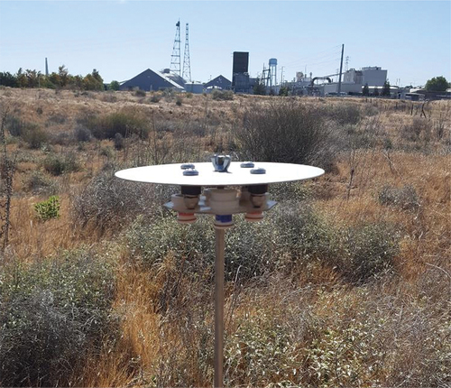 Figure 3. The passive sampler deployed on the Sardis unit with the gypsum facility in the background. The image is facing west-southwest. The gypsum plant is approximately 400 m from this sampler.