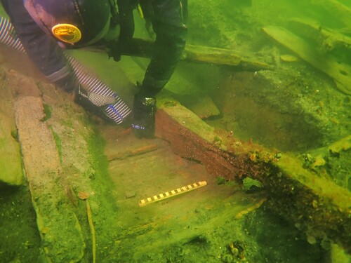 Figure 22. Diver excavating next to a top timber at the point of transition from the carvel lower hull to the lapstrake stern castle, shown by the ‘joggles’ cut to accommodate the overlapped planks. (Photo: Johan Rönnby).