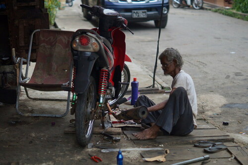 Figure 3. An older man at work repairing motorbikes (photograph by Samia C. Akhter-Khan).