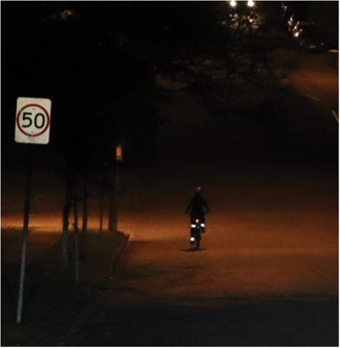 Figure 5. Image of a cyclist wearing biomotion strips on the leg joints cycling away from the driver in a suburban street.