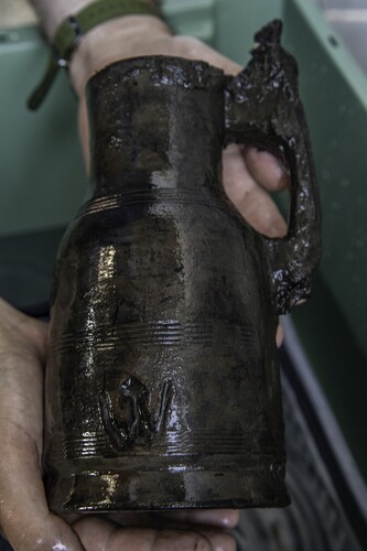 Figure 17. A turned wood tankard with a lid, 220 mm high and with a base diameter of 120 mm. These drinking vessels are known as ‘red jugs’ (röda kannor, Kjellberg, Citation1964). In addition to turned decorative mouldings, the lower part of the body has a large, incised image of a crown which closely corresponds with the heraldic type used during the late fifteenth century in Denmark. For example, in design it is almost identical to the three crowns on the shield of King Hans’ Great Seal. The motif does not necessarily mean that the tankard was the king's personal drinking vessel, but it probably does label it as royal property (Rönnby, Citation2020, pp. 57–58). Indeed, the written sources tell us that the king lost his whole ‘fatabur’ (household) in the wrecking. (Photo: Brett Seymour, The Gripshund Project).