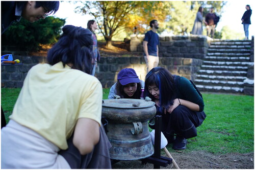 Figure 4. Audience inspection of a Đông Sơn drum. Footscray Community Arts Centre, 2021. (Photographic documentation of community performance courtesy of James Nguyen and Victoria Pham).