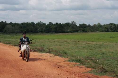 Figure 4. A motorcyclist rides across the earth bund of a semi-natural Elangawa reservoir in Sri Lanka. In Galgamuwa, Kurunegala district, the United Nations Development Programme is leading a project designed to restore Elangawa as ‘nature-based solutions’ to water insecurity worsened by climate change. Photo: Stephen Woroniecki