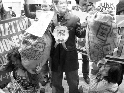 Fig. 2. A domestic worker disguised as Indonesian President Yudhoyono was presented with the “Rookie Labor Exporter of the Year” award as he balanced two large bags of Hong Kong dollars on the backs of domestic workers. 1 5 December 2005. (Credit: Photographs courtesy of the author unless otherwise noted.)