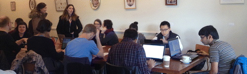 Figure 5. A large table in a café is filled up with small groups and solitary persons.