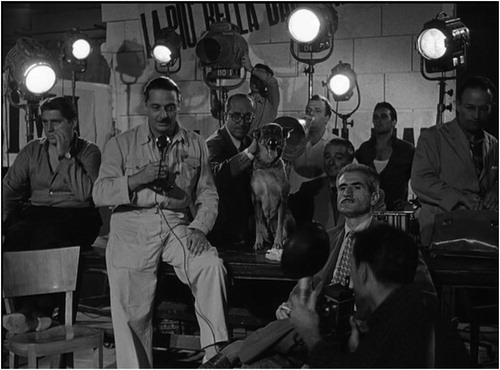 Figure 3. Blasetti (at centre, with microphone, wearing trademark overalls), the elder statesman of the postwar years, playing the director in Bellissima (Luchino Visconti, 1952) (screenshot).
