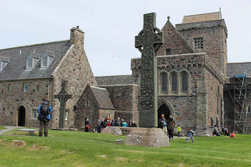 Figure 2. Crosses from left to right, St John’s (replica in original base), St Matthew’s (empty base in front of group of visitors) and St Martin’s, in front of Iona Abbey. Photographer Sally Foster.