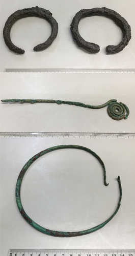 Fig. 3. Two iron bangles (top) found with a bronze pin (middle) and bronze neck ring (bottom) in Täby, Uppland (SHM 29348). Photo: Thomas Eriksson, The Swedish History Museum/SHM (CC BY).