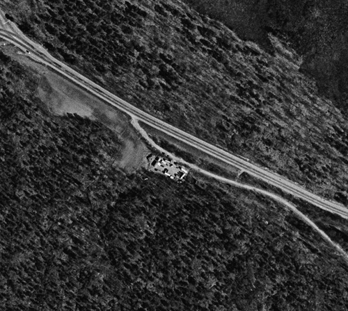 Figure 4. Aerial photo from the Skarpnäck Camp area, 1960. The camp is clearly visible, built as a square around a courtyard, with an exit at the north-east, towards the road. Note the vast forested area surrounding the camp. Photo courtesy of Lantmäteriet.
