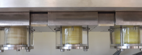 Figure 3. Multistage setup with Rousselet BXP025 centrifugal contactors modified with PMMA lower rotor housing; in operation with simulated PUREX feed solution (left to right: 2nd extraction stage, 1st extraction stage, 1st scrubbing stage).