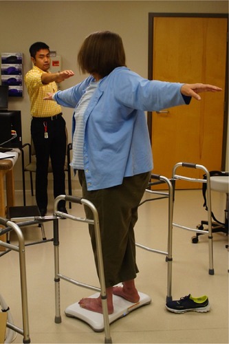 Figure 1 Setup of researcher, participant, TV, and Wii Balance Board during the Torso Twist balance task.