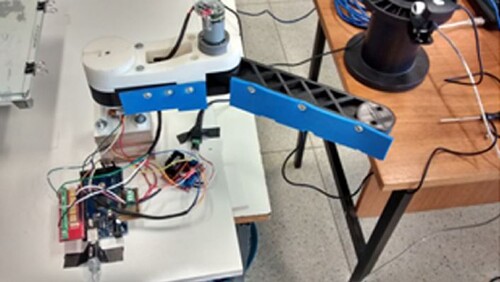 Figure 11. The robotic arm responsible for pushing the parts. The blue side is what touches the part during the removing process (Aroca et al. Citation2017).