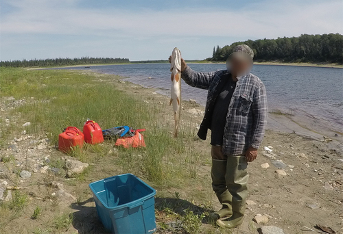 Figure 5. An Elder holding up a recently caught fish. (Photo credit: Participant 23).
