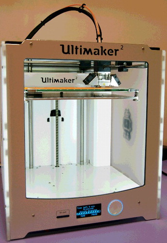 Figure 1. One of our Ultimaker printers in action. The cartoon robot is visible in reverse, through the transparent right-hand side.