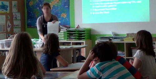 Figure 6. Teacher explaining the hand out boxes to fill in for the results of the water filtering task.