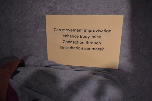 Figure 3. (Student C) shows an image from, cardboard square that says ‘Can movement improvisation enhance Body-mind Connection through Kinesthetic awareness?’.
