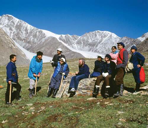 Figure 1. 1981 in the Tien Shan (Mountains of Heaven) when China was still closed to foreign visitors. Our group walked to Glacier Number 1 (background–right). Roger is wearing white gloves and Gordon Young is seated next to him. Professor Shi Yafeng, China’s founder of glaciology, pointing to a distance feature, later visited us in Boulder, Colorado. Photo: Jack Ives