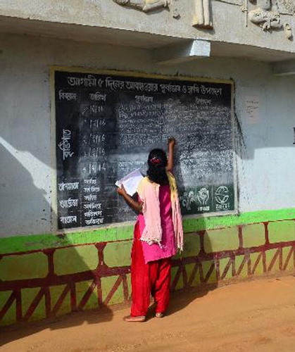 Figure 6. Village volunteer updating blackboard.