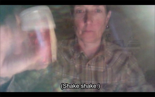 Figure 6. Still frame of Derbyshire shaking a sequin-filled pill bottle, with a caption reading ‘(Shake, shake.)’ From Mrs. Green by Jan Derbyshire.