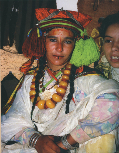Figure 1. Brightly colored motifs and elaborate silver and amber jewelry that ‘Berber’ women occasionally wear (Becker, Citation2006, p. 43).