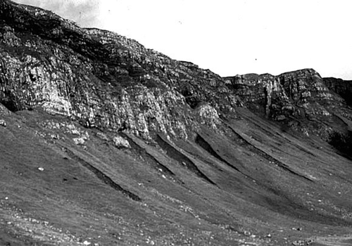 Figure 13 Relict talus accumulations at the foot of the Trotternish escarpment, northern Skye. Radiocarbon dating of buried soils exposed in gullies incised into the talus has allowed reconstruction of the history of talus accumulation and reworking by debris flows at this site. Most talus accumulation occurred in the Lateglacial and early Holocene