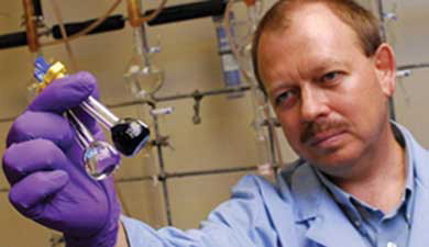 Figure 1 Dmitry M. Rudkevich in his lab (UT Arlington) demonstrating the chemical fixation of NOx by calix[4]arenes: a colorless solution of pure calix[4]arene instantly turned purple upon a short-time exposure to NO2/N2O4.[Citation52] © The University of Texas at Arlington. Reproduced by permission of The University of Texas at Arlington. Permission to reuse must be obtained from the rightsholder.