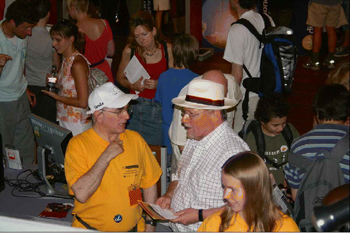 Figure 3. An estimated number of 10,000 visitors came to our stand to learn about liquid crystals, their properties and their applications. Tim Sluckin is trying hard to convince the other guy with a hat, that there really is so much more to liquid crystals than just flat panel displays.