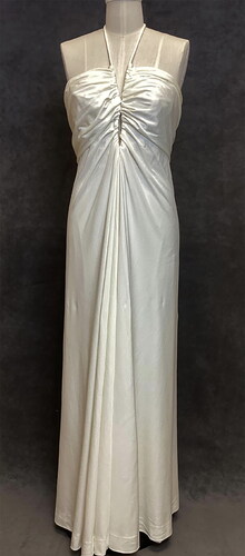 Figure 7 Luis Estévez, cream-colored, floor-length evening gown, full front view, nylon and metal, ca. 1975. ISU Textiles and Clothing Museum, 2022.7.3. Photograph by authors. <https://tcm.catalogaccess.com/objects/11339>