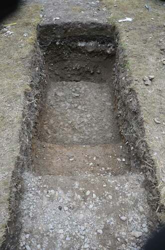 Figure 7. Photo from trench nr 2, showing the stratigraphic sequence. The lower surface corresponds to the layer of gravel laid by Stockholm municipality in 1959; the middle surface to the thin occupation layer of the camp (1959-1963); the upper surface in the foreground is the layer of gravel used as a foundation for the stone-breaker post in 1963. Photo Anna Arnberg.