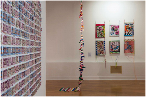 Figure 17 Installation view with foreground in focus of Migrations, Huddersfield Gallery of Art, England (October 22, 2016 - January 21, 2017). Left: Claire Barber You Are the Journey (An Embroidered Intervention) (2015), used ferry tickets, reclaimed yarn, pins, and needle weaving over used ferry tickets (detail); middle: Françoise Dupré, Stripes, started in 2009 in Mostar, Bosnia-Herzegovina with straps of bags used in OUVRAGE project - 2011 woven webbing, straps from carrier bags and thread, bamboo cane, and hooks; right: Françoise Dupré, Arabesques, Stars with Dragon (2014), wall hanging installation, stitched woven and printed polythene, polyester/cotton bias, thread, quilting pins, acrylic knitted flat braids, and six stainless steel screw rings.