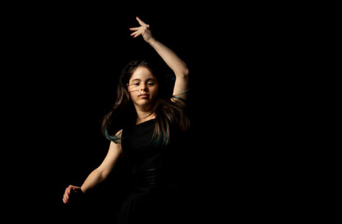 Figure 1. Jianna Georgiou dancing in a black dress against a black background, Restless Dance Theatre, Seeing Through Darkness, 23 December 2020. Photo Shane Reid