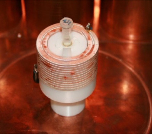 Figure 4 Transmit and receive setup of a magnetic particle spectrometer.Notes: The nanoparticle samples are placed in the center of the send and the receive coil. The coils are manufactured of a high frequency litz wire and are glued and pressed to avoid vibrations.