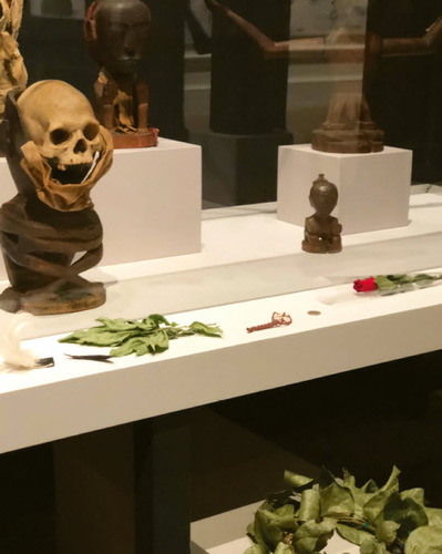 Fig. 3. Offerings left at the Oceania exhibition at the Royal Academy London: a feather, flowers, a wreath etc — below the display of human remains (cropped out of the image), 2018. © Lucia Patrizio Gunning