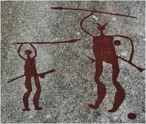 Figure 14. A rock carving from Tanum in Bohüslan depicting a similar motif to that found at Bro Utmark. In this carving, a large horned-figure and a smaller non-horned figure are wielding spears in a position similar to that of Bro Utmark, possibly waving them. Both of the figures are also depicted naked and with sword scabbards attached to their waists. Several characteristics—including the cup marks surrounding the figure on the right, its exaggerated characteristics and larger size, and its horns—have led many to characterize this motif as a possible depiction of a heroic or divine figure from Bronze Age myth leading a mortal in the weapon dance (Horn et al. Citation2018).