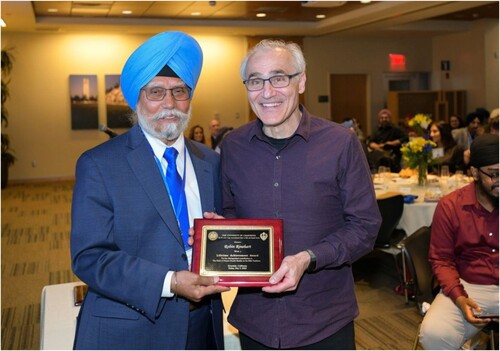 Figure 13. Louis E. Fenech receiving the award from Pashaura Singh on behalf of Robin Rinehart for her contribution to the Dasam Granth studies.