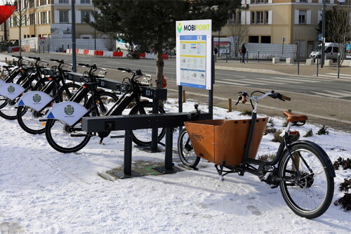 Figure 1. eHUB with shared electric bicycles and an e-cargobike next to an information panel. Image provided by the courtesy of the City of Dreux, France, partner of the eHUBs project. Source: Ville de Dreux—Photo: Jean Cardoso. Reprinted with permission.