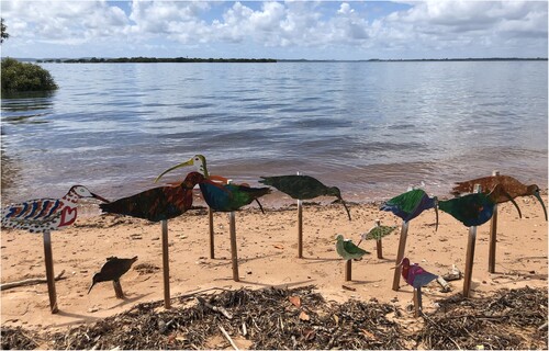 Figure 11. Painted wooden shorebirds, staked in the gritty shoreline at a community event.
