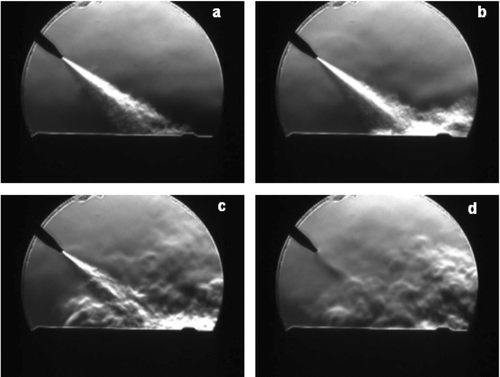 FIG. 3 Four frames of Schlieren images that capture the jet pulse sequence (a) developing jet, (b) the stream impacting the surface, (c) the jet dissipating, and (d) the end of pulse.