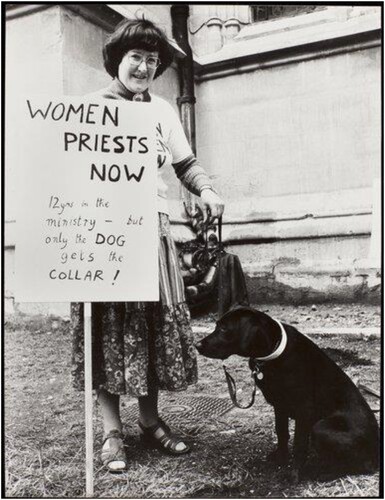 Figure 3. Bernice Broggio displays a placard which reads: ‘WOMEN PRIESTS NOW 12yrs in the ministry – but only the DOG gets the COLLAR!’. TWL/2004/238. Orphan Licence: OWLS000401-1.