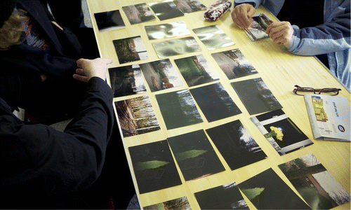Figure 1. A photo from the workshops showing image analysis and photo-elicitation with a participant. The images were taken during the initial disposable camera project. We categorized them into ‘themes’ based on the content. Many of the shots were taken in the dark evenings to highlight the remoteness and isolation of the area, or from inside their houses looking out onto the dark landscape. Photo Gary Bratchford©.