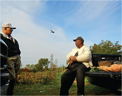 Opening Figure. A. J. Wade and Curtis Walton in October, 2012 at the Kinloch farm Curtis helped cultivate prior to its relocation for the grocery distribution complex. A plane from nearby Lambert Airport takes off overhead. Image © Christian Gooden, St. Louis Post-Dispatch/ POLARIS.