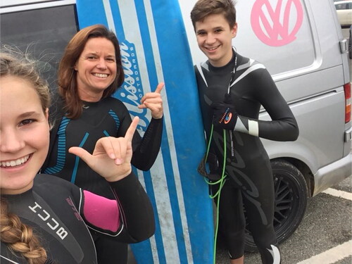 Figure 9. Natalie, Lucy and Tom in wetsuits, with Tom holding a surfboard.Source: Authors.