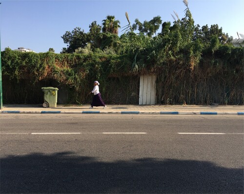 Figure 4. An Ethiopian woman walks past Bayārat Abu Seif.
