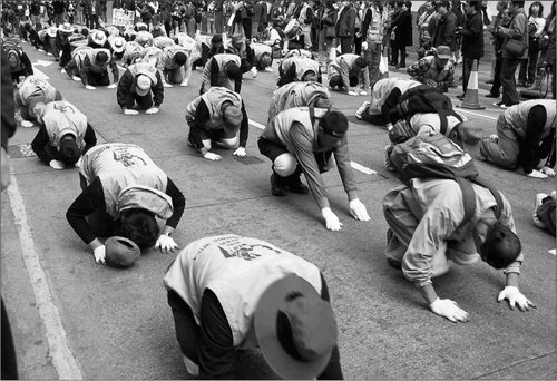 Fig. 9. In one anti-WTO protest march on 1 5 December 2008, Korean farmers (whose jackets read “WTO kills farmers”) processed from Causeway Bay to Wanchai by walking three steps then bowing their heads to the ground. This kowtowing, an ancient Buddhist rite, moved some local observers to tears.