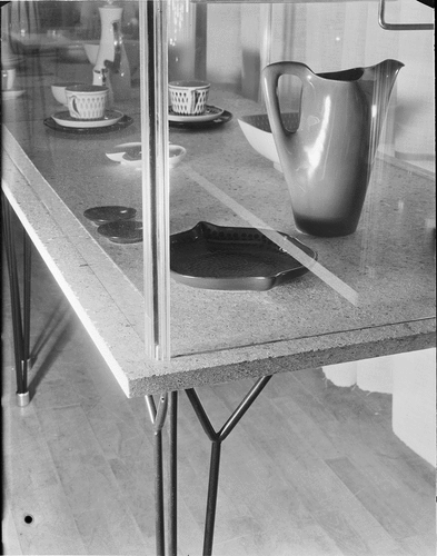 Figure 3. Detail of one of Myrstrand’s display tables at the “test” installation at Frey’s Warehouse in Stockholm, March 22, 1954. Composite timber tabletops, transparent acrylic corner supports and black “String” legs. Photographer Sune Sundahl. ArkDes, Stockholm. ARKM.1988-111 -16,331. Public domain.